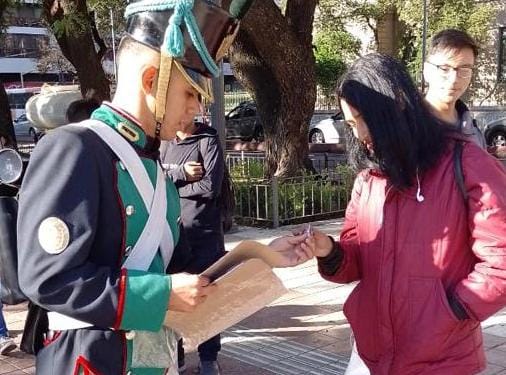 La guardia oficial del Cabildo reparte escarapelas en la plaza Colón